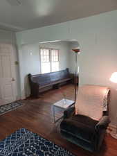 Living area featuring wood finished floors and arched walkways