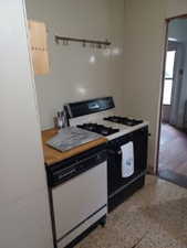 Kitchen featuring range with gas stovetop, dishwasher, and speckled floor