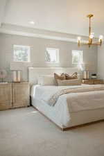 Bedroom featuring a chandelier and multiple windows