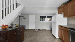 Kitchen with dark countertops, tasteful backsplash, and baseboards