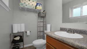 Bathroom with vanity, toilet, tile patterned flooring, and baseboards