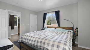 Bedroom featuring carpet and baseboards