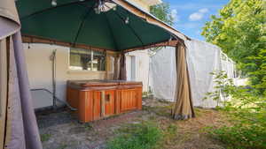 View of outbuilding featuring a hot tub and a gazebo