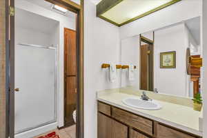 Bathroom featuring a shower stall, vanity, toilet, and tile patterned floors