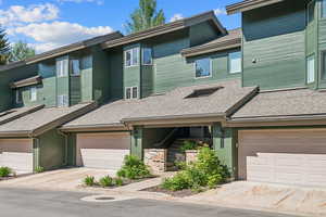 Townhome / multi-family property featuring roof with shingles and concrete driveway