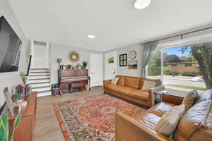 Living area featuring light wood-style floors, stairway, and recessed lighting
