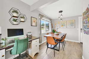 Dining space with light wood-type flooring, baseboards, and a desk