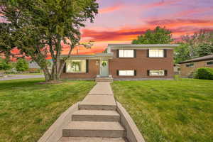 Split level home featuring brick siding and a lawn
