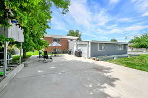 Rear view of house with an outbuilding and a patio