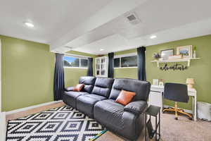 Carpeted living room with a textured ceiling, baseboards, and recessed lighting