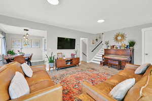 Living room featuring wood finished floors, stairway, and baseboards