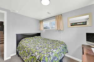 Bedroom featuring carpet floors, a textured ceiling, and baseboards