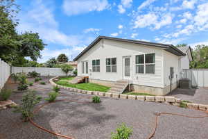 Rear view of property featuring entry steps, cooling unit, and a fenced backyard