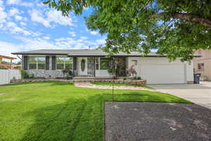 Single story home featuring an attached garage, driveway, and covered porch