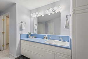 Bathroom with vanity, tile patterned flooring, and baseboards