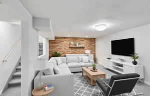 Living room with brick wall, stairs, baseboards, light carpet, and recessed lighting