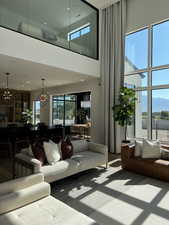 Living room featuring a chandelier, a high ceiling, a mountain view, and wood finished floors