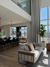 Living room with wood finished floors, a chandelier, and a high ceiling