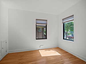 Spare room featuring light wood-type flooring and baseboards