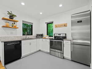 Kitchen featuring stainless steel appliances, a sink, white cabinets, healthy amount of natural light, and recessed lighting