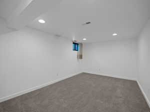 Unfurnished room featuring recessed lighting, dark carpet, and baseboards