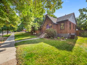 View of side of property featuring brick siding, central AC unit, a shingled roof, and a chimney
