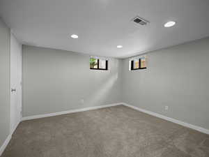 Carpeted empty room with recessed lighting and baseboards