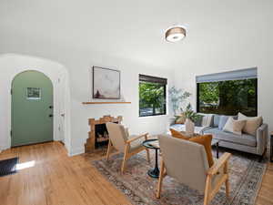 Living room featuring light wood-style floors, baseboards, and arched walkways