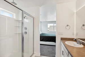 Full bathroom featuring a stall shower, ensuite bath, and vanity