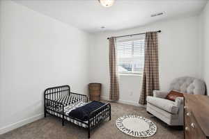 Carpeted bedroom featuring baseboards