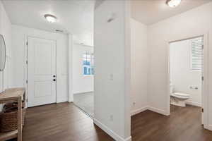 Entryway featuring dark wood-style floors and baseboards