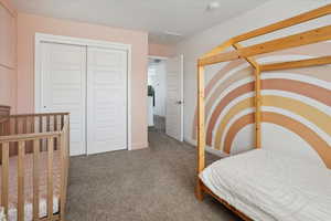 Bedroom with carpet, a closet, and baseboards