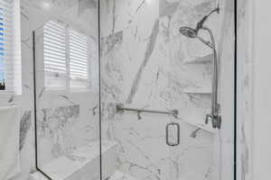 Bathroom featuring a marble finish shower