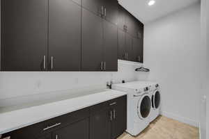 Laundry room with cabinet space, washing machine and dryer, recessed lighting, baseboards, and light tile patterned floors