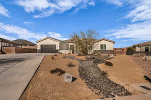 Ranch-style home featuring stone siding, driveway, stucco siding, an attached garage, and a tile roof