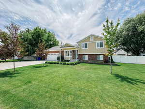 Split level home featuring brick siding, driveway, and an attached garage