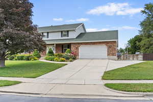 Traditional-style home with a garage, concrete driveway, a shingled roof, brick siding, and a porch