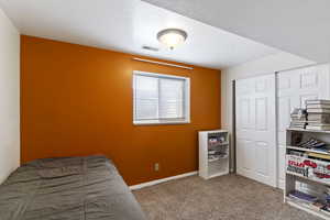 Bedroom featuring carpet, a closet, and baseboards