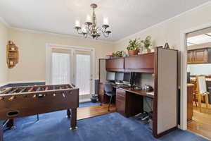 Office space featuring crown molding, a chandelier, and carpet