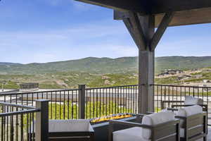 Balcony featuring a mountain view and an outdoor living space with a fire pit