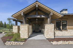 Entrance to property featuring stone siding and a chimney