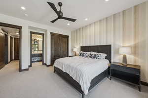Bedroom featuring baseboards, wallpapered walls, light carpet, a barn door, and recessed lighting