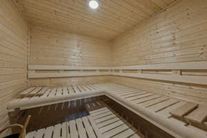 Relaxing sauna featuring wooden walls and wooden ceiling