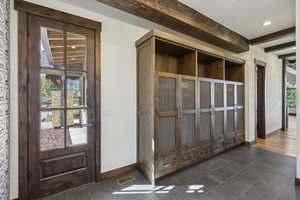 Detailed view of baseboards, beam ceiling, and recessed lighting