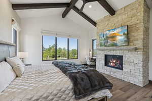 Bedroom featuring wood finished floors and a fireplace