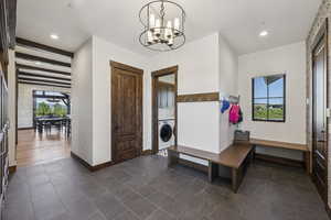 Entryway featuring washer / dryer, plenty of natural light, baseboards, a chandelier, and recessed lighting