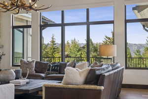 Living area featuring a chandelier, wood finished floors, baseboards, a mountain view, and plenty of natural light