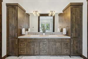 Full bathroom with double vanity, a chandelier, and marble finish floors