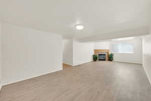 Another view of basement family room with gas fireplace and new vinyl flooring