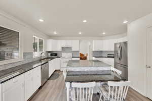 Kitchen with large center island and kitchen bar. Enjoy the warmth of durable vinyl flooring, sleek recessed lighting, and an open layout that creates a bright and inviting space.